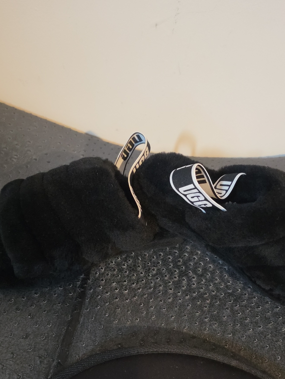 UGG Fluff Yeah Slides in black, featuring plush sheepskin and a logo-branded ela